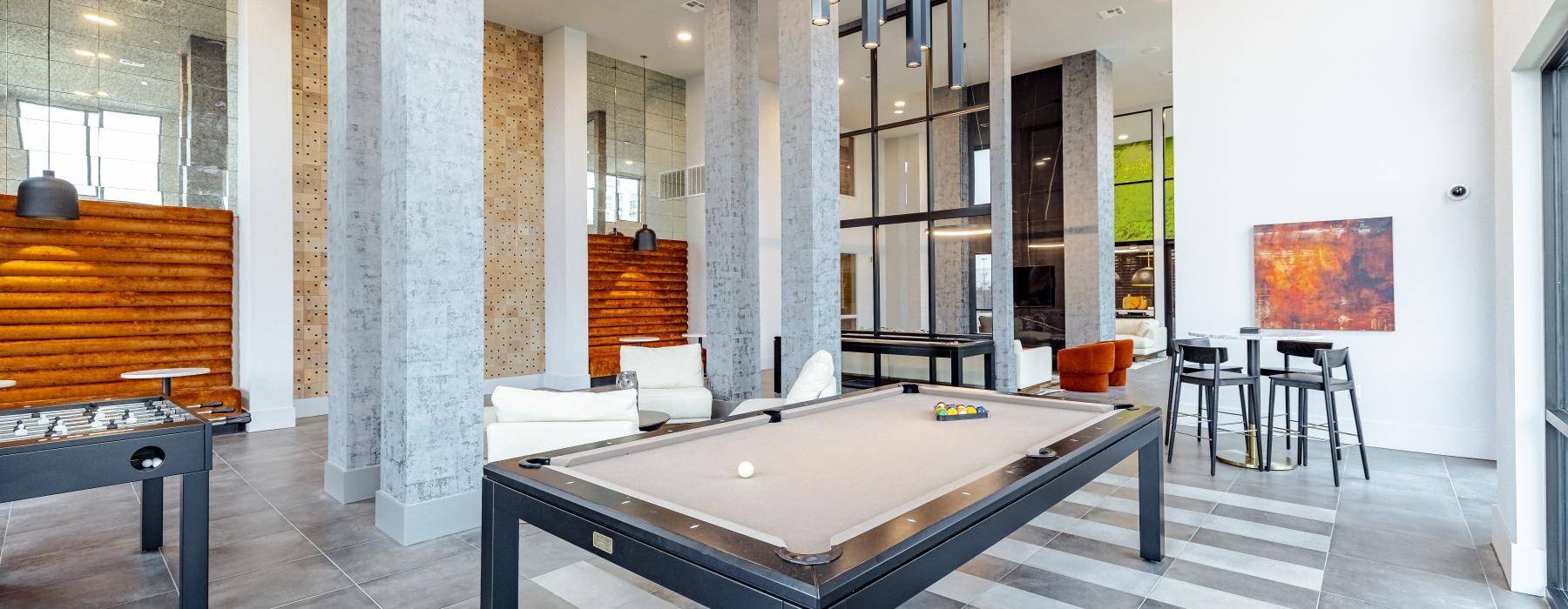 a room with a pool table and chairs